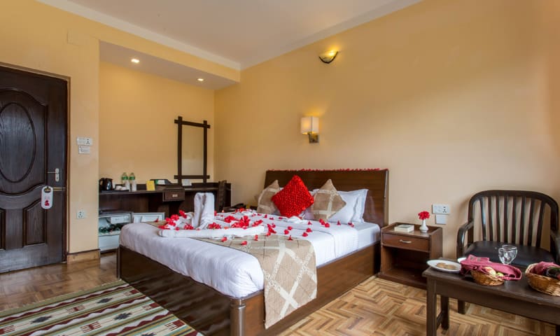 Full view of the Honeymoon Super Deluxe with seating area and decorated bed