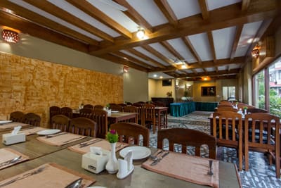 Restaurant tables in front of a textured stone feature wall