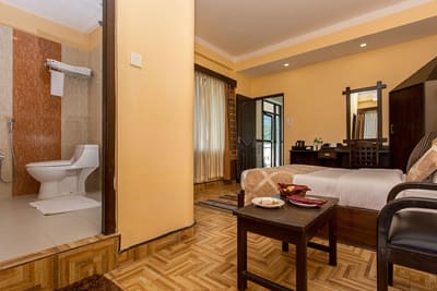 Bedroom seen past the open door of a tiled en-suite bathroom