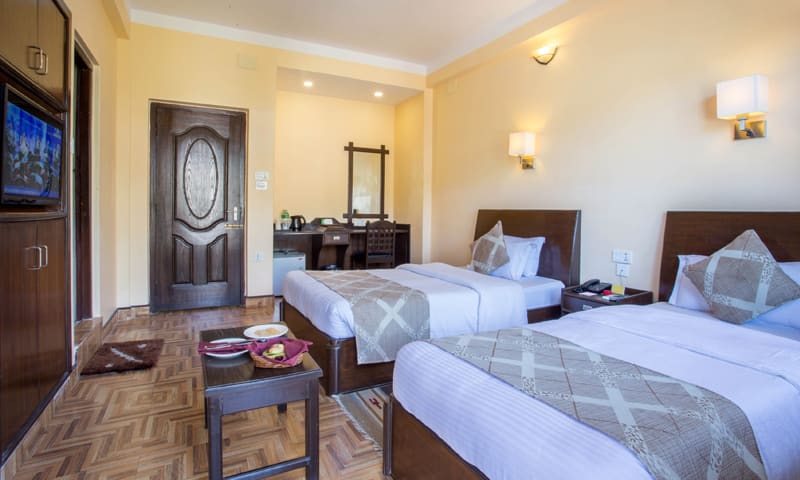 Super Deluxe room set up with twin beds and a low table